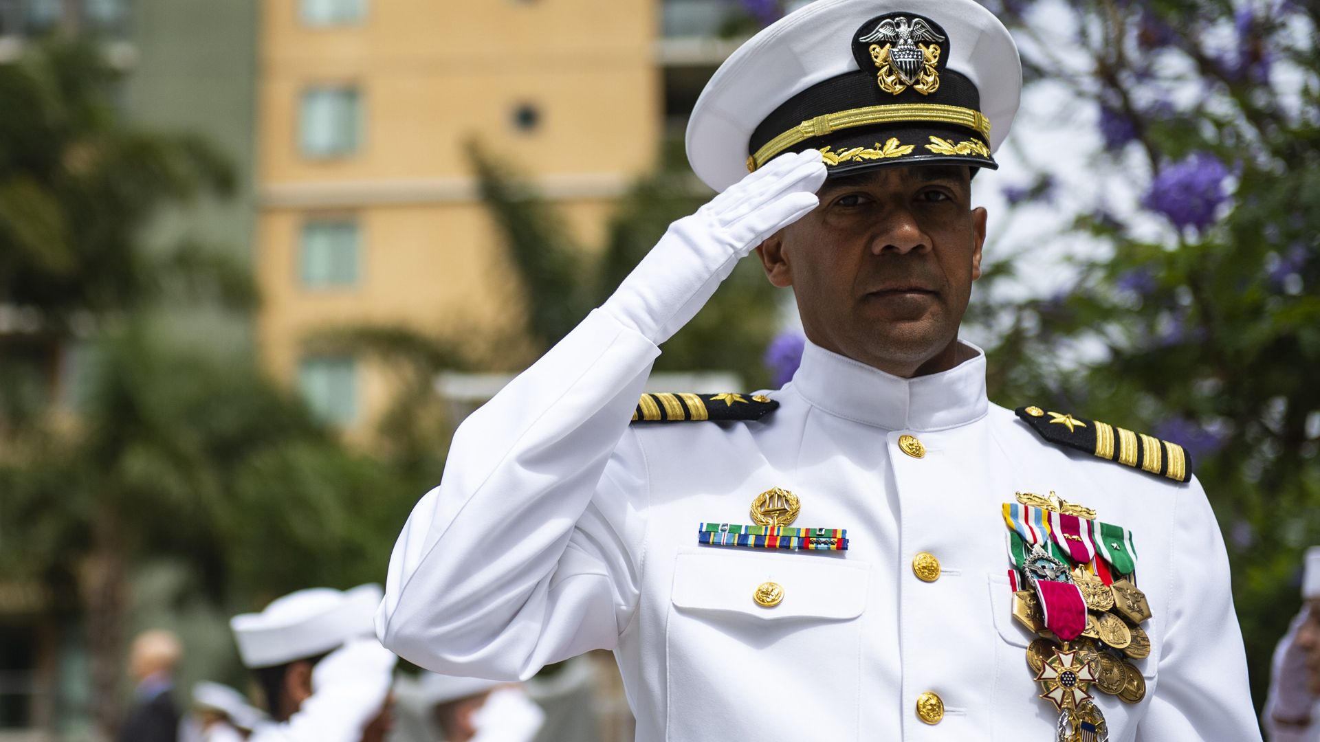 A man is dressed in his full dress military uniform salutes
