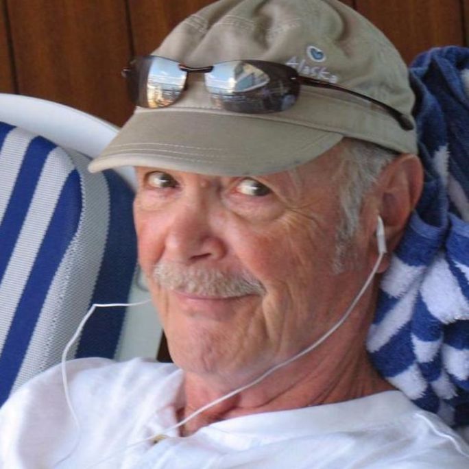 Photo of middle-aged man, sporting a dashing moustache and smiling wrily to camera.