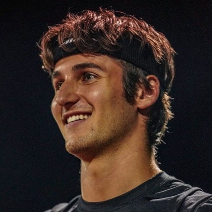 Side view portrait of smiling, athletic man in sports attire.