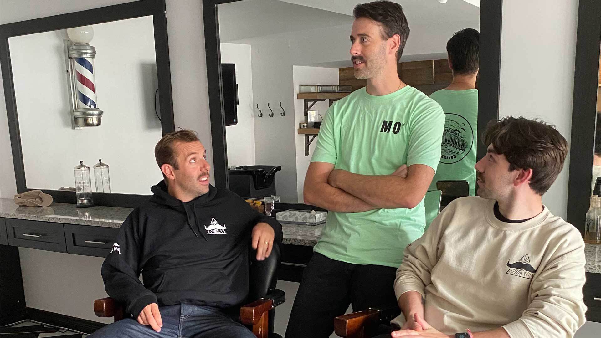 Photo of three men wearing Movember-branded merchandise.