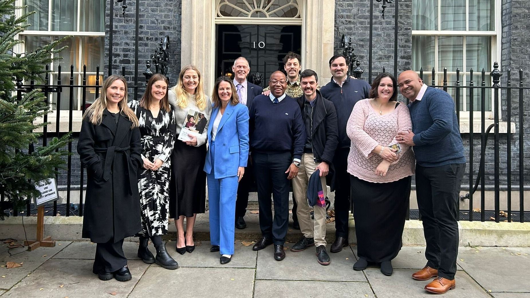 Photo of UK government officials and Movember personnel in front of #10 Downing Street.