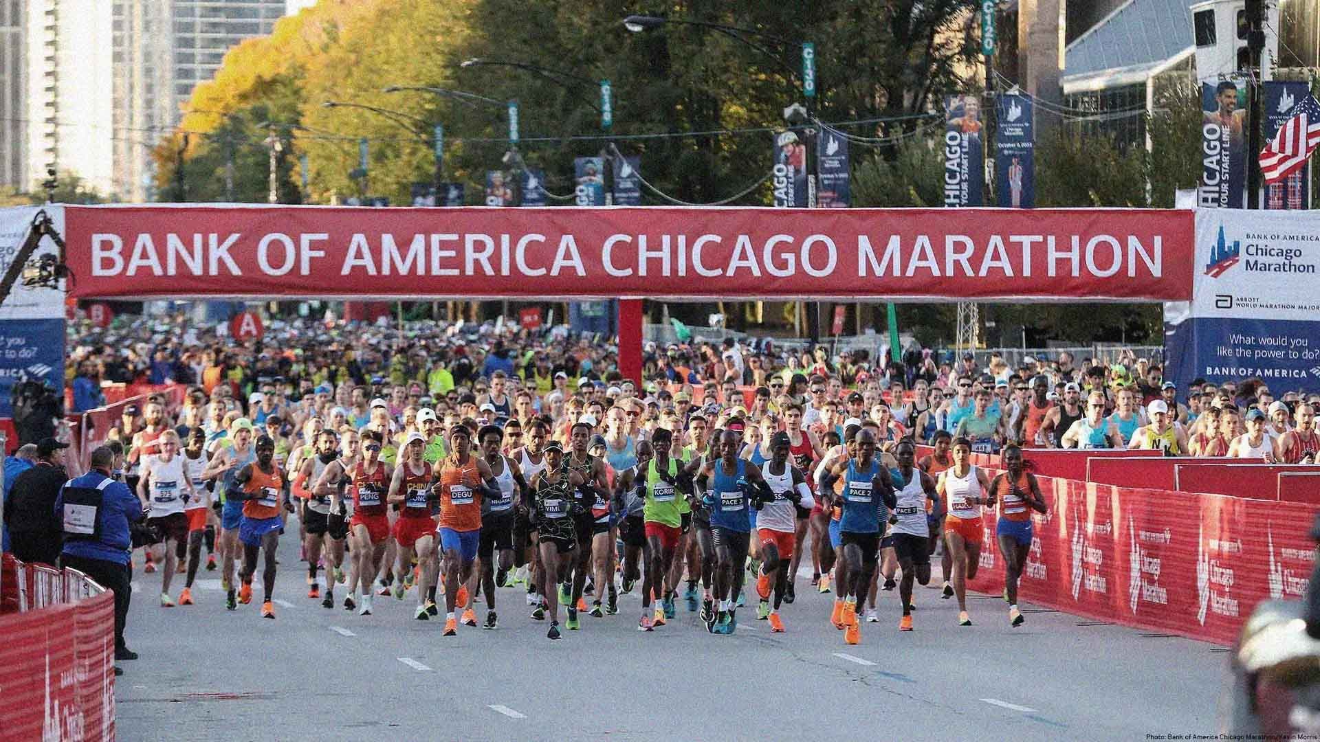 Hundreds of runners taking off from the start line at the Chicago Marathon. A large sign reads: "Bank Of America Chicago Marathon."