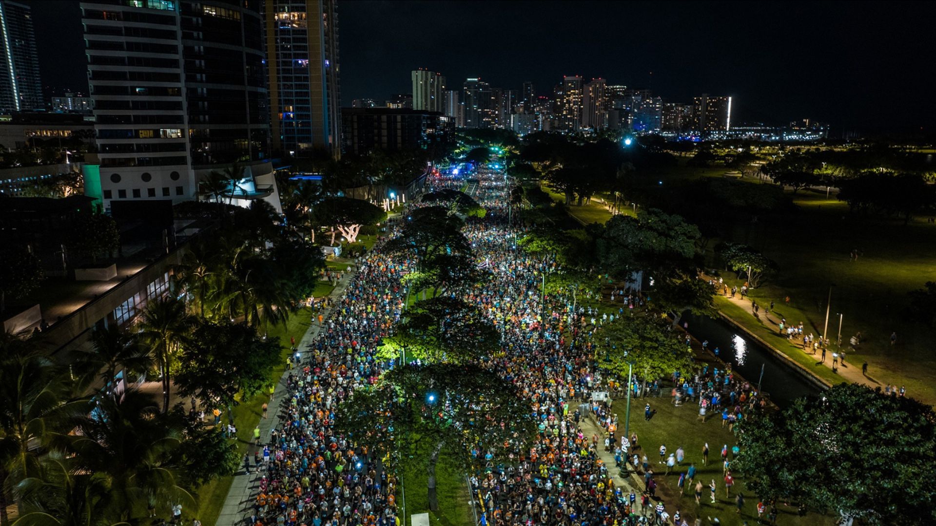 Runners at the start line of the Honolulu Marathon in the dark.