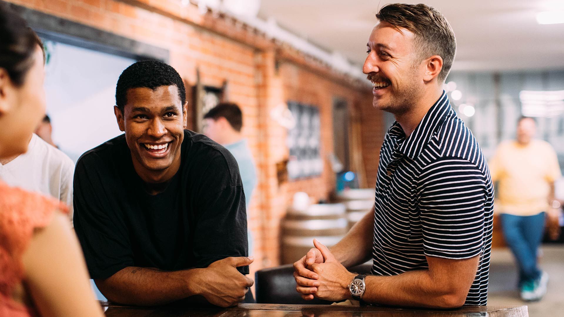 Photo of smiling men with moustaches, talking about supporting Movember at their workplace.