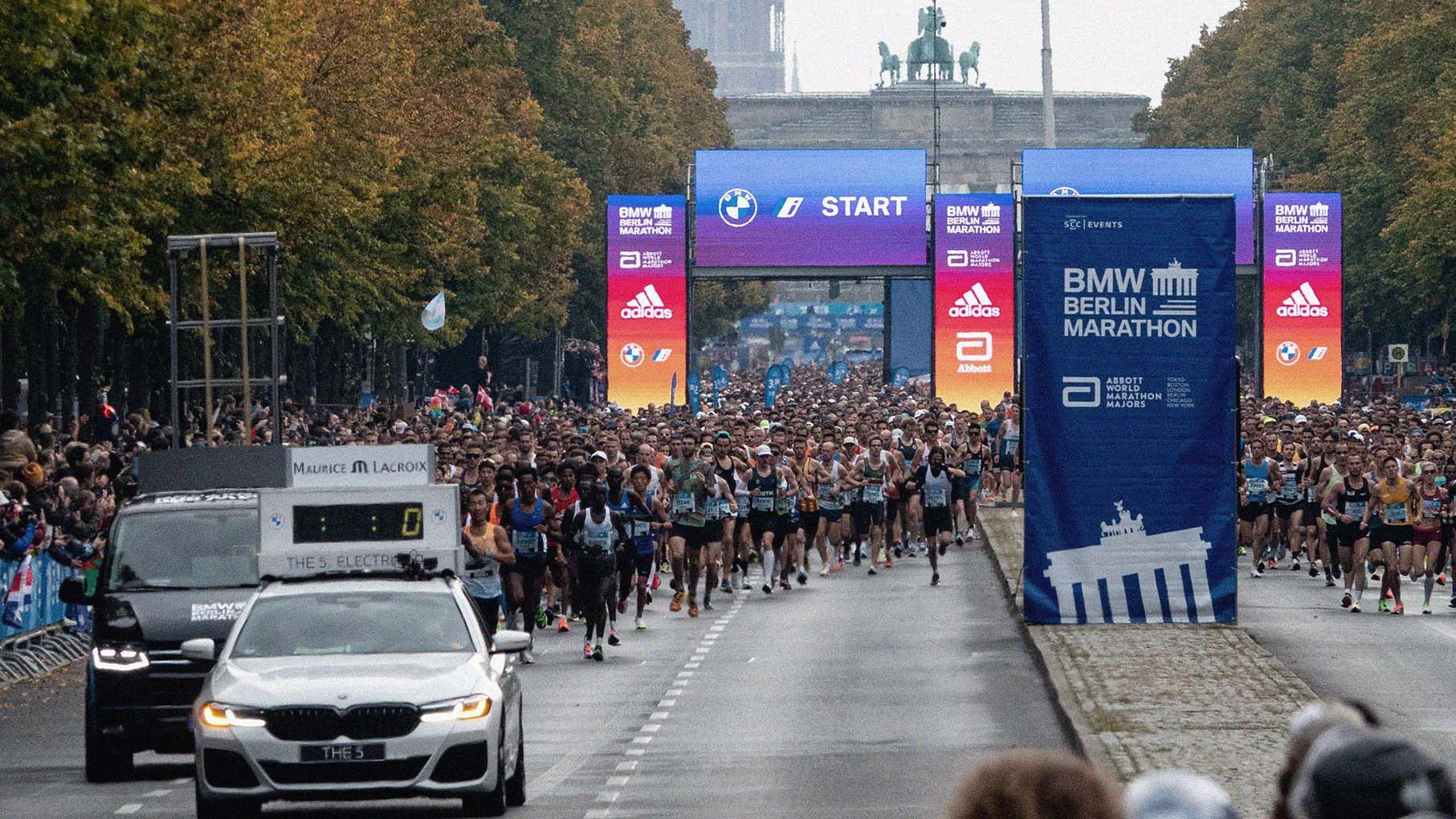 Wide-angle photo showing thousands of runners leading the Berlin Marathon.