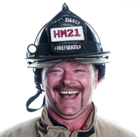 Firefighter in helmet smiling at camera.