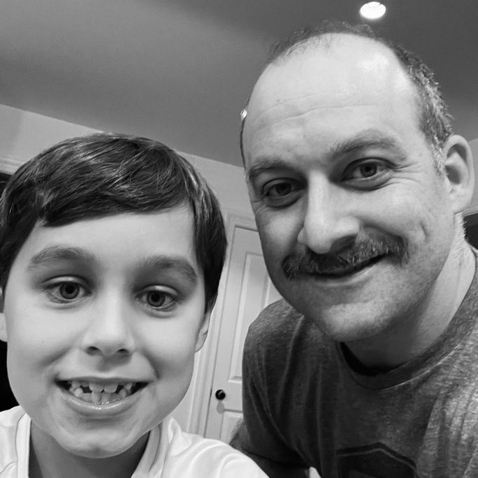 Black and white photo of a man and his son looking to camera.