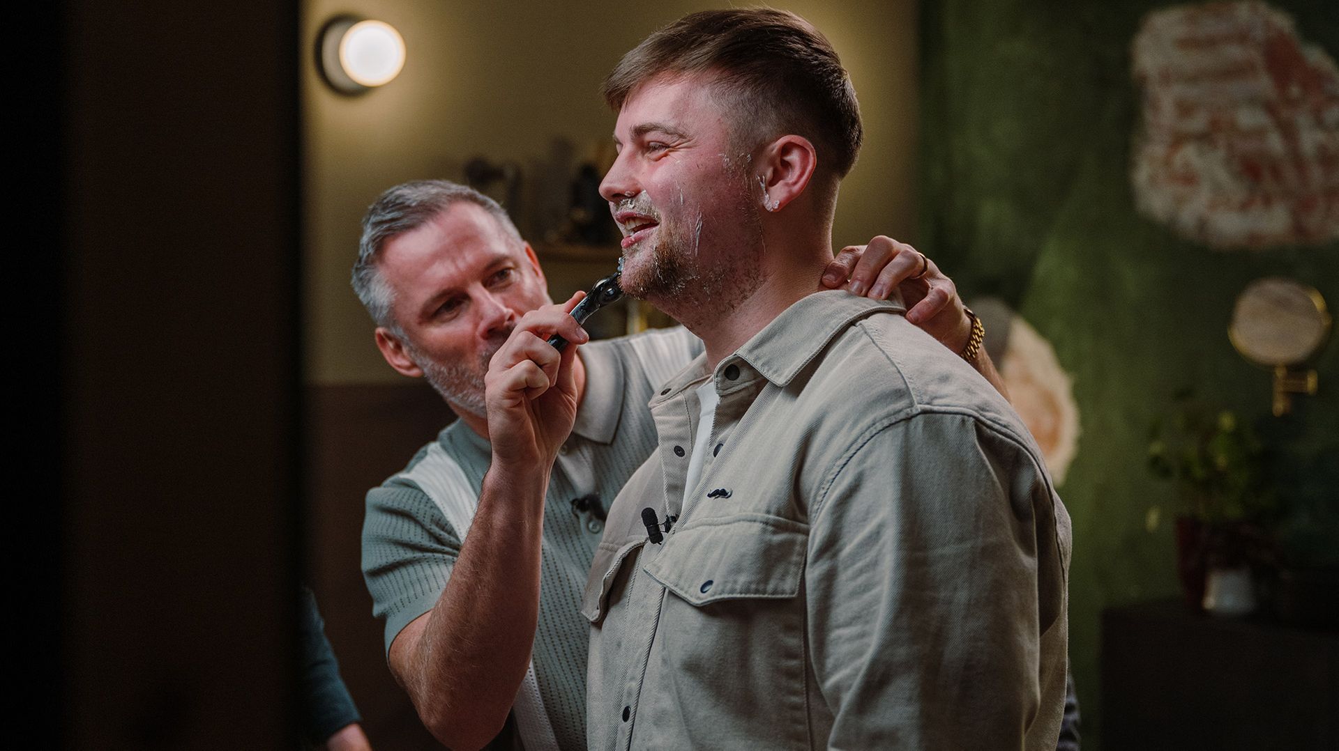 Photo of a man helping another man shave for Movember using a Gillette razor.