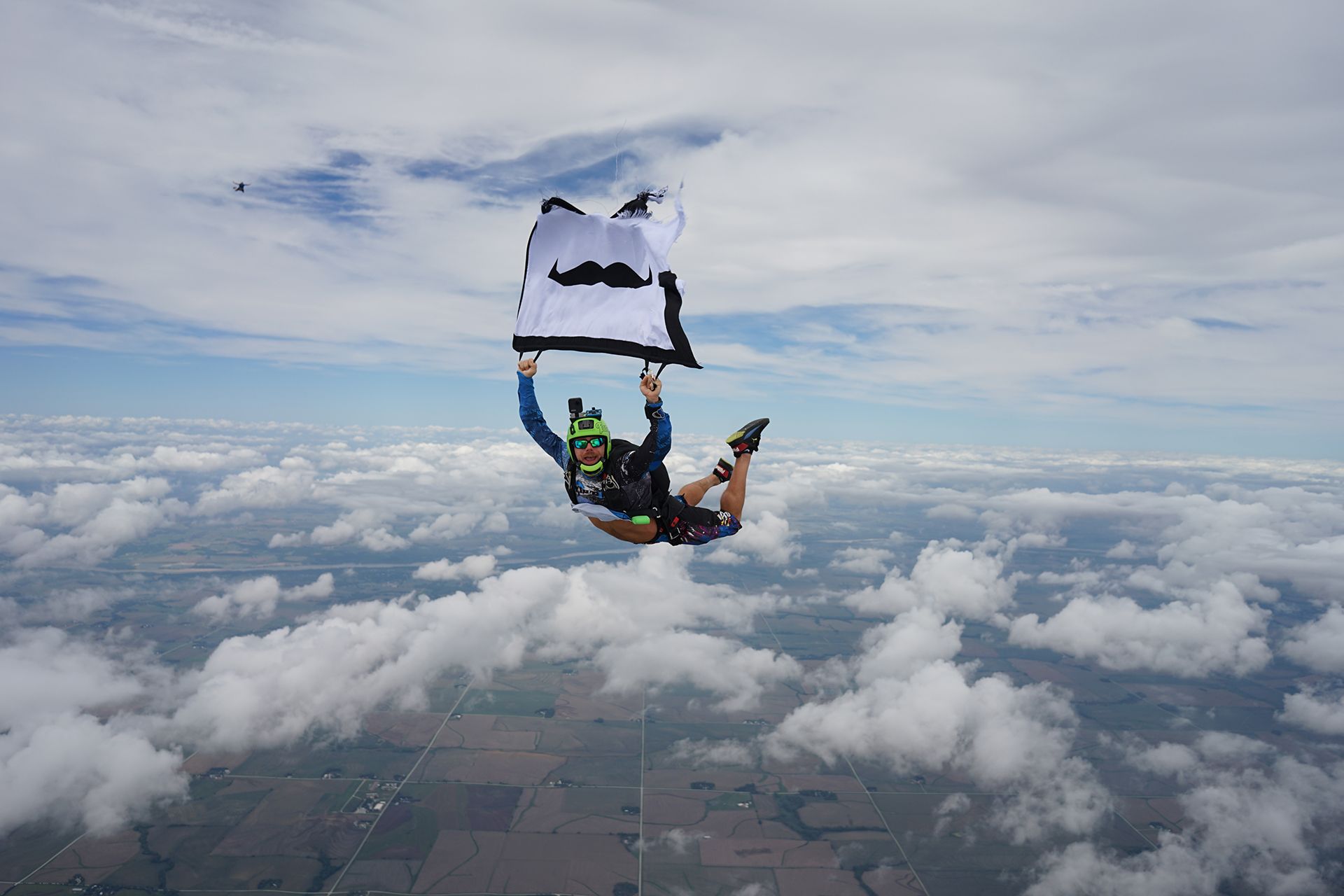 Skydiver holding Movember flag