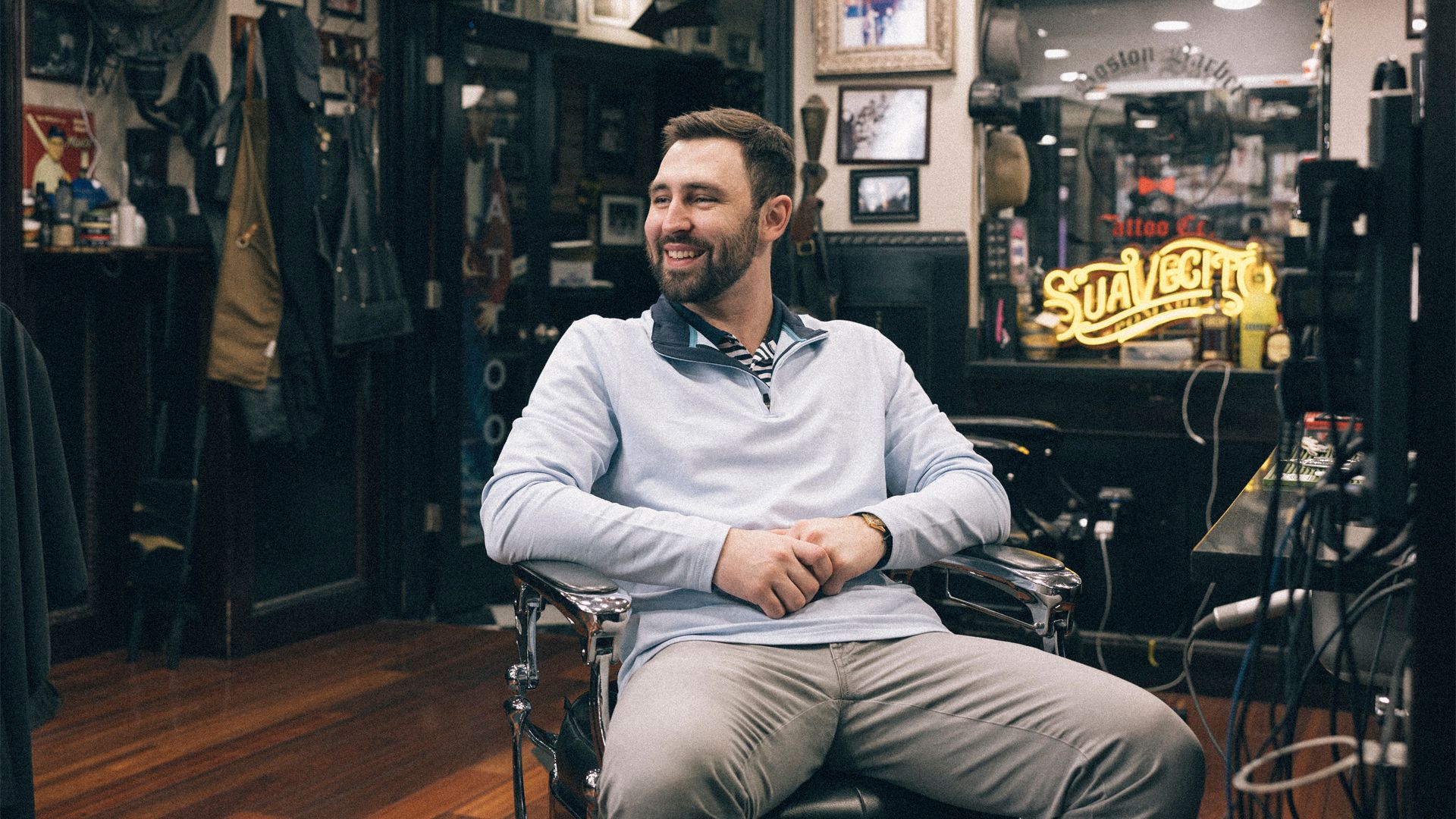 A man poses for his portrait from a barber chair