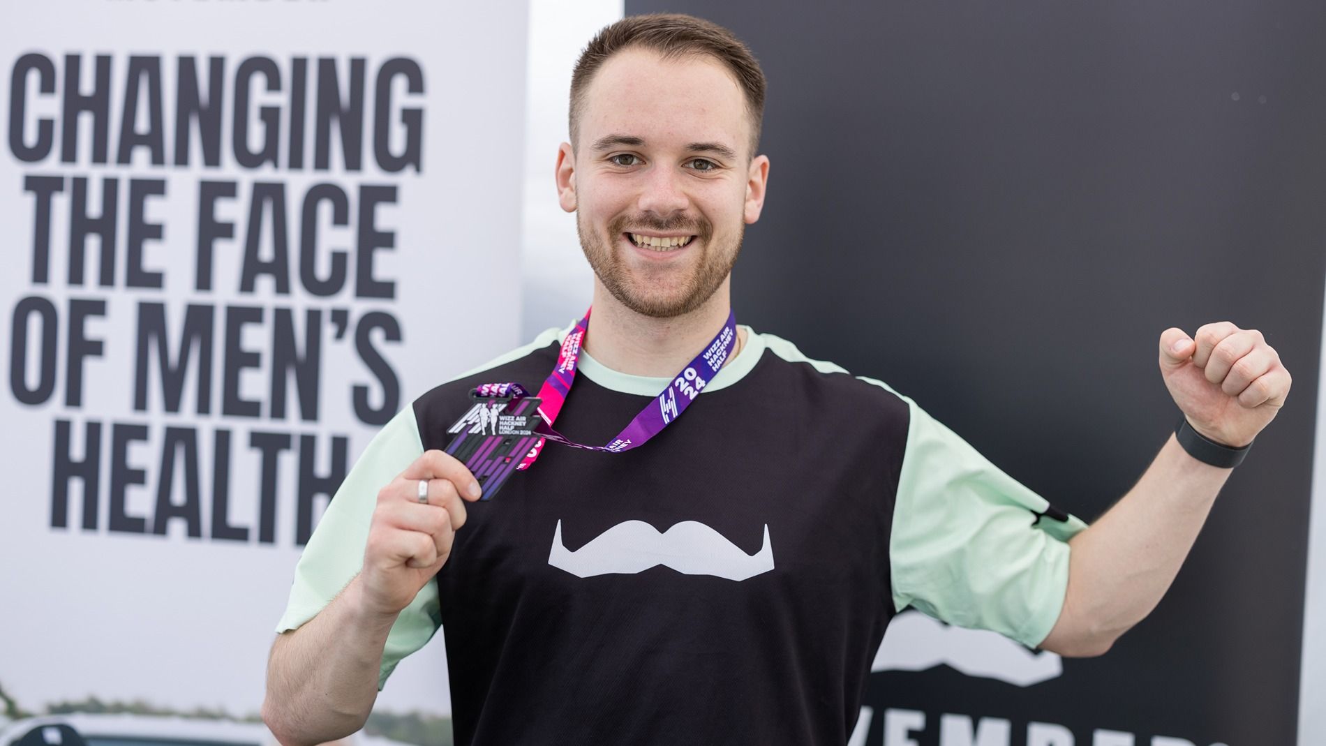 Will holding his medal at the Hackney Half marathon finish line.